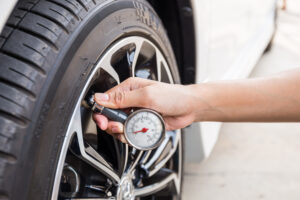 Close-Up Of Hand holding pressure gauge for car tyre pressure me